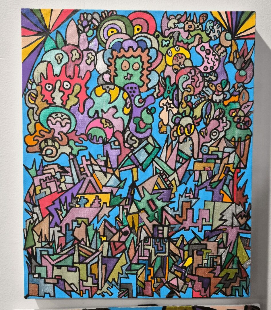 Colorful abstract mural with various shapes, patterns, and cartoon-like characters on a wall.