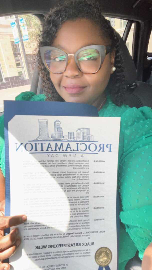 Person with glasses holding a Proclamation document inside a vehicle.